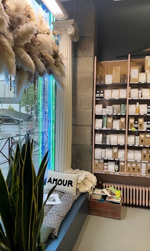 Coin déco avec colonne, coussin Amour, pampas séchées et plante verte près de la vitrine